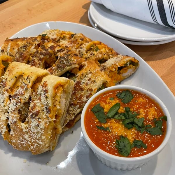 Savory bread rolls with herbs and cheese, served with a side of tomato dipping sauce.