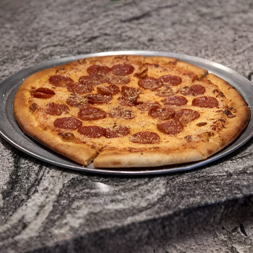 A whole pepperoni pizza with a slice removed, on a metal tray, resting on a granite countertop.